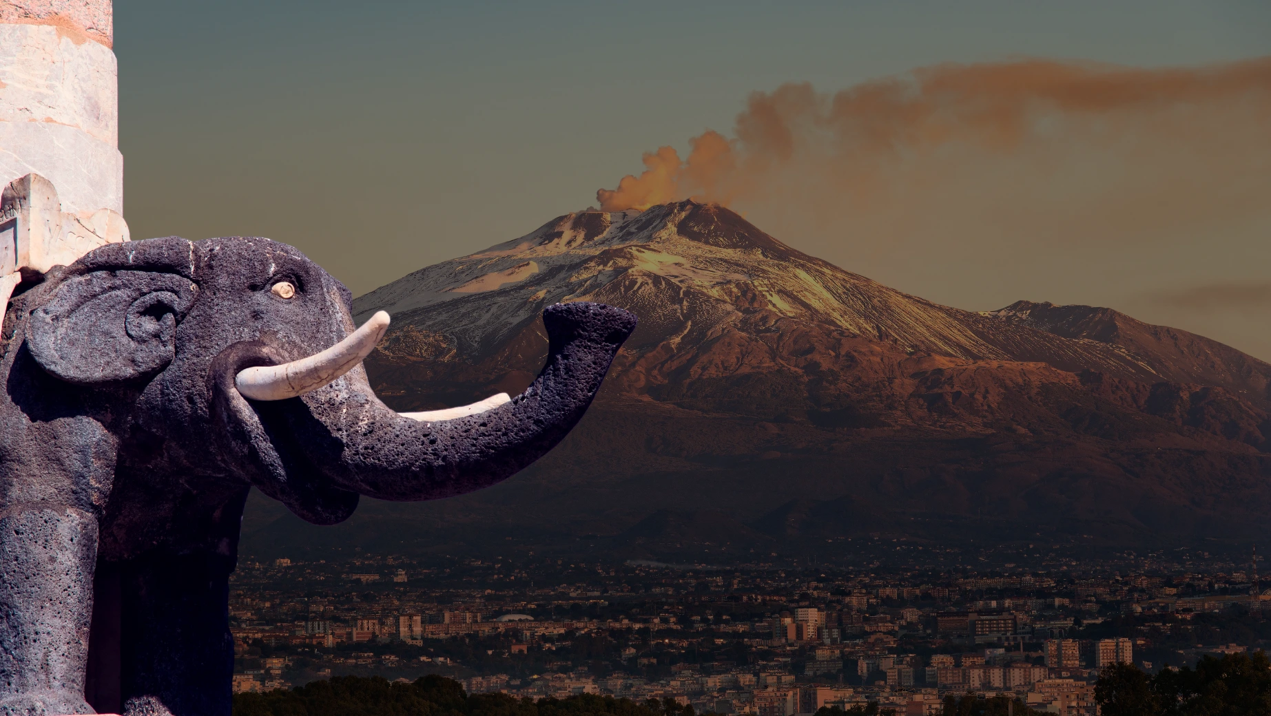 elefante-simbolo-di catania-in-primo-piano-sullo-sfondo-l-etna-che-fuma